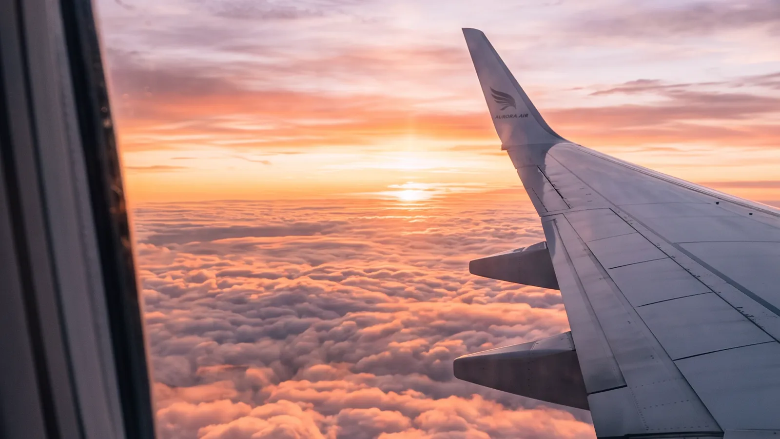 Ala de un avión vista desde la ventanilla sobre un mar de nubes al atardecer